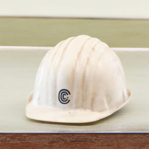 A white hardhat sitting on a desk